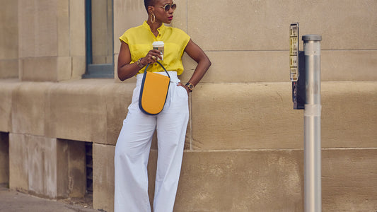 Style Influencer Farotelle in a color-blocked look consisting of white pants, a yellow shirt, and a yellow bag.